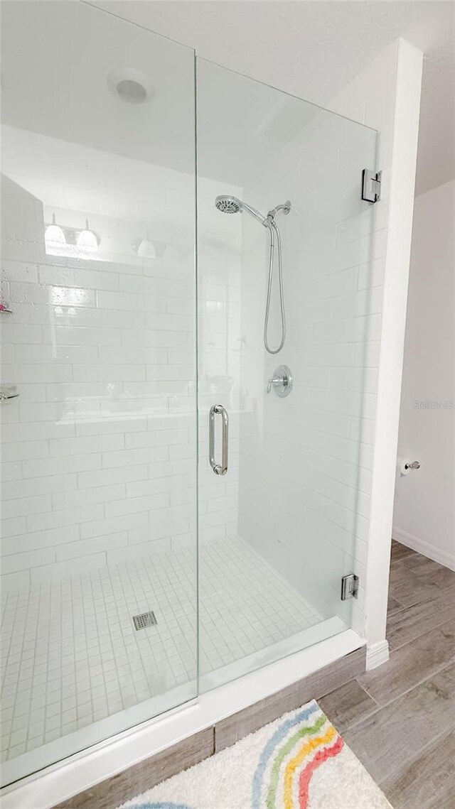 721 Benoi Dr, Davenport, FL 33896 - bathroom featuring a stall shower and wood finished floors