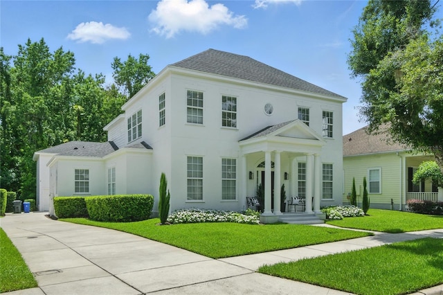 933 Jasmine St, Celebration, FL 34747 - view of front of home featuring concrete driveway, a front lawn, a shingled roof, and stucco siding