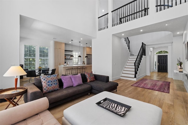 933 Jasmine St, Celebration, FL 34747 - living room featuring light wood finished floors, stairway, a towering ceiling, and recessed lighting