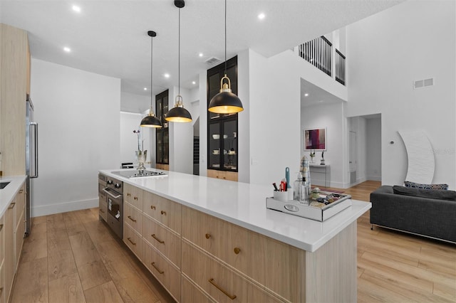 933 Jasmine St, Celebration, FL 34747 - kitchen featuring light brown cabinets, modern cabinets, black electric stovetop, light wood-style floors, and light countertops