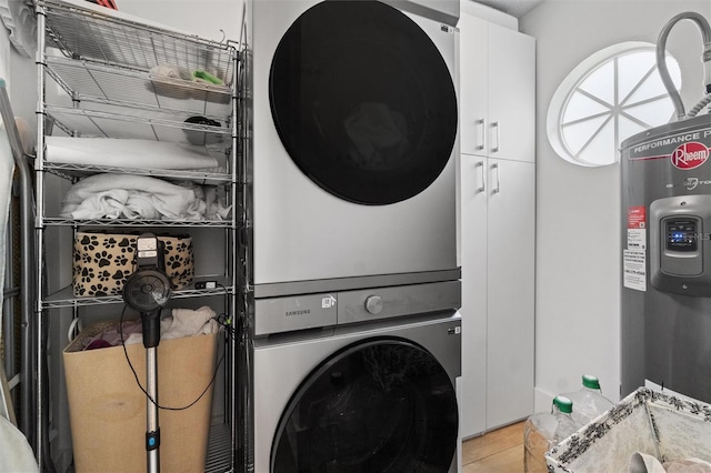 933 Jasmine St, Celebration, FL 34747 - laundry area featuring cabinet space, stacked washer / drying machine, light tile patterned flooring, and electric water heater