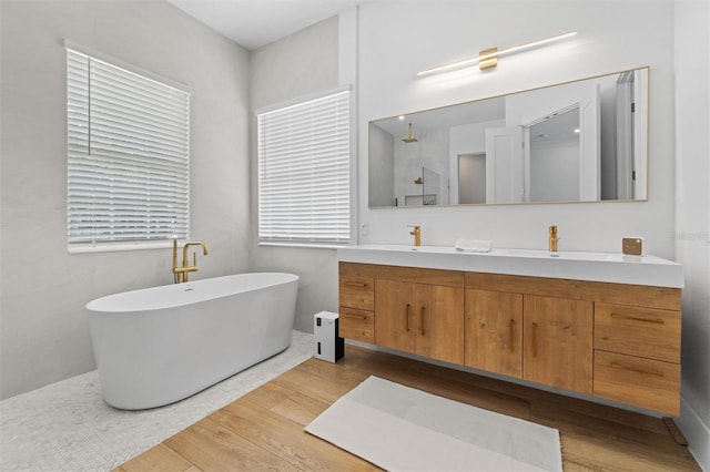 933 Jasmine St, Celebration, FL 34747 - full bath with wood finished floors, double vanity, a freestanding tub, and a walk in shower