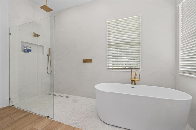 933 Jasmine St, Celebration, FL 34747 - full bathroom featuring a walk in shower, a freestanding bath, and wood finished floors