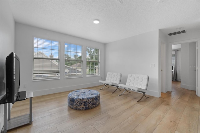 933 Jasmine St, Celebration, FL 34747 - sitting room featuring healthy amount of natural light, light wood-style floors, and a textured ceiling