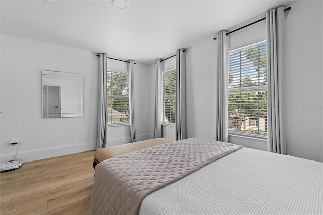 933 Jasmine St, Celebration, FL 34747 - bedroom with light wood-style floors, multiple windows, and a textured ceiling