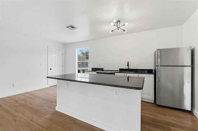 933 Jasmine St, Celebration, FL 34747 - kitchen with freestanding refrigerator, dark countertops, wood finished floors, and white cabinetry