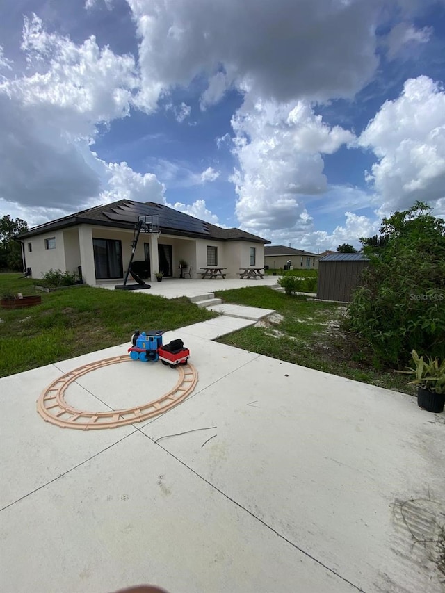 2408 Conroy Ave N, Lehigh Acres, FL 33971 - back of house featuring a patio area, a shed, solar panels, and stucco siding