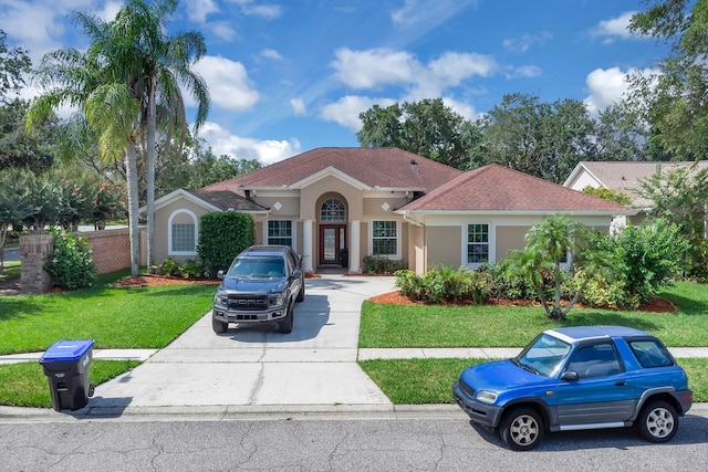 2402 Raven Croft Ct, Orlando, FL 32837 - mediterranean / spanish home featuring stucco siding, a front yard, and driveway