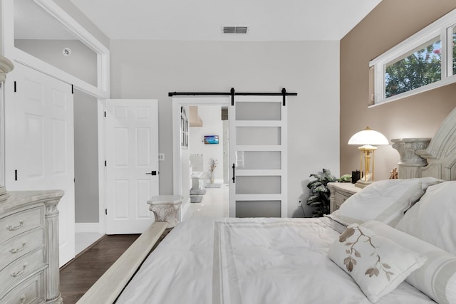 2402 Raven Croft Ct, Orlando, FL 32837 - bedroom featuring a barn door and dark wood-type flooring