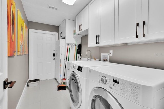 2402 Raven Croft Ct, Orlando, FL 32837 - laundry area with cabinet space, washing machine and clothes dryer, and tile patterned floors