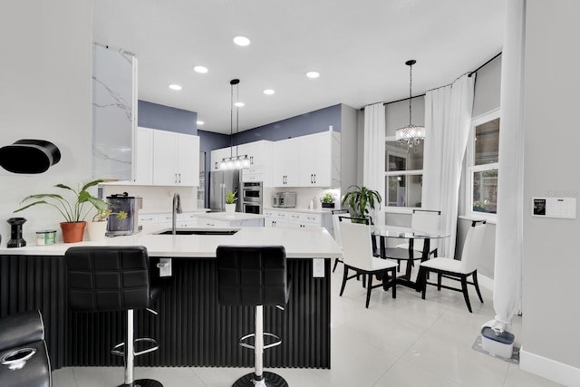 2402 Raven Croft Ct, Orlando, FL 32837 - kitchen with a peninsula, light countertops, white cabinets, appliances with stainless steel finishes, and a kitchen bar