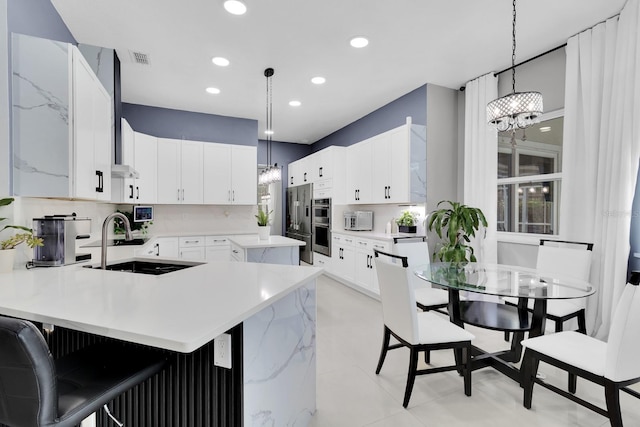 2402 Raven Croft Ct, Orlando, FL 32837 - kitchen featuring a chandelier, a peninsula, tasteful backsplash, recessed lighting, and white cabinets