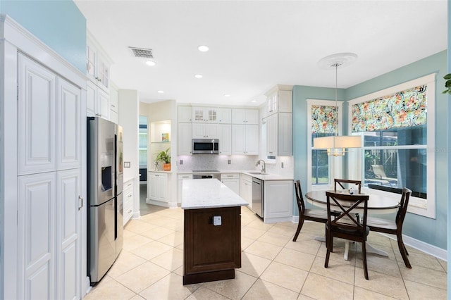 716 Timberwilde Ave, Winter Springs, FL 32708 - kitchen with appliances with stainless steel finishes, a kitchen island, glass insert cabinets, tasteful backsplash, and light tile patterned flooring