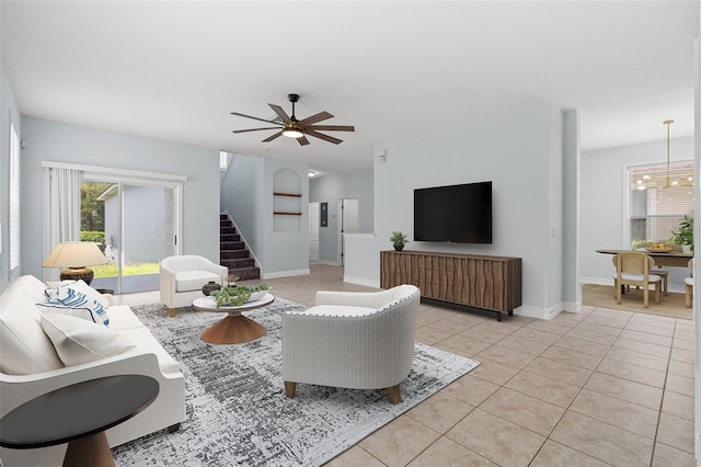 6905 Beargrass Rd, Harmony, FL 34773 - living area featuring light tile patterned floors, ceiling fan, and stairs