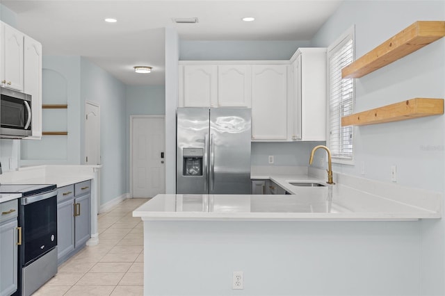 6905 Beargrass Rd, Harmony, FL 34773 - kitchen with open shelves, appliances with stainless steel finishes, white cabinets, a peninsula, and light countertops