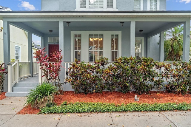 6905 Beargrass Rd, Harmony, FL 34773 - view of exterior entry featuring a porch and stucco siding