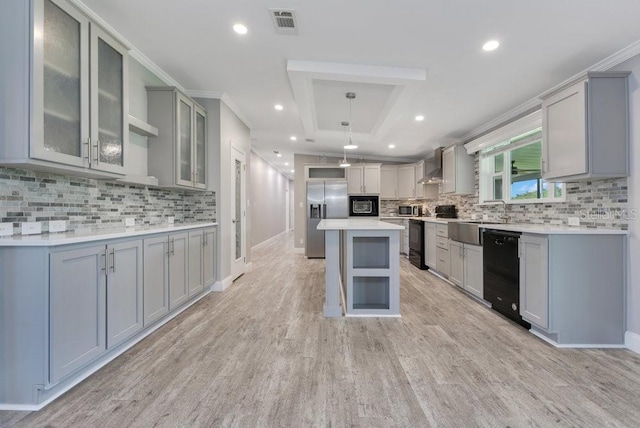 4361 Albritton Rd, Saint Cloud, FL 34772 - kitchen with black appliances, wall chimney exhaust hood, a center island, decorative backsplash, and light countertops