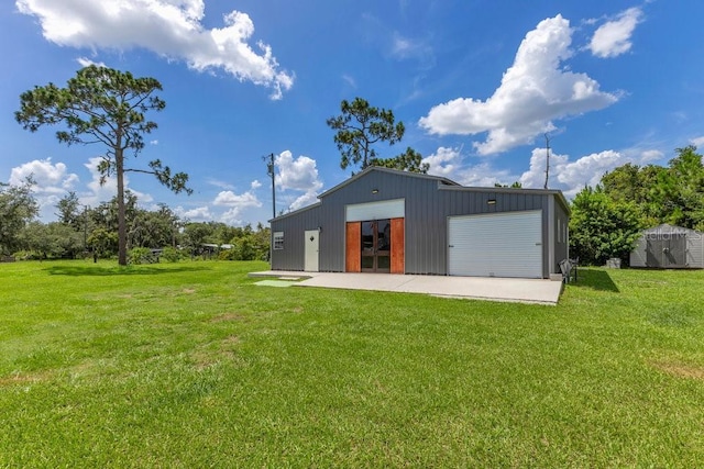 4361 Albritton Rd, Saint Cloud, FL 34772 - back of house with an outbuilding, a detached garage, and a lawn