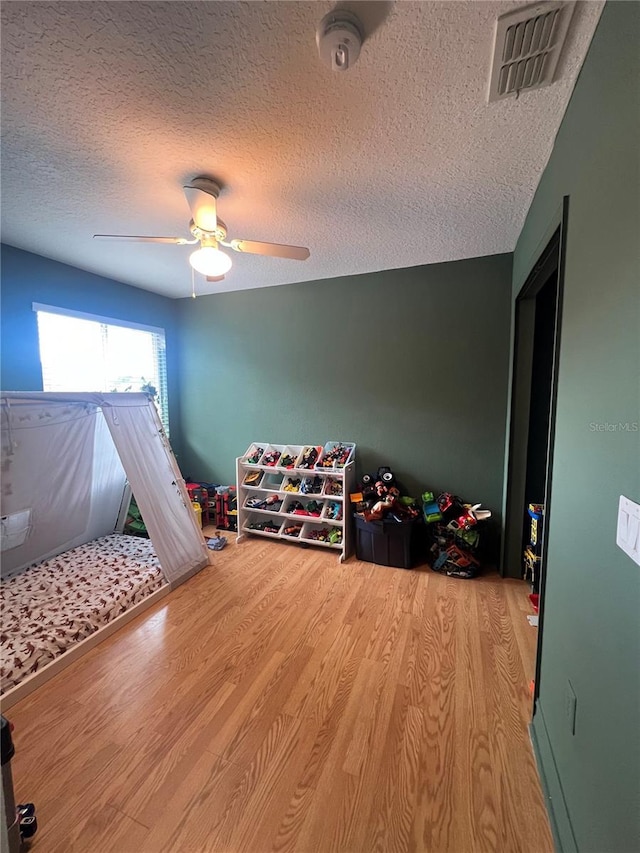 3339 Primrose Willow Dr, Saint Cloud, FL 34773 - game room with wood finished floors, a textured ceiling, and a ceiling fan