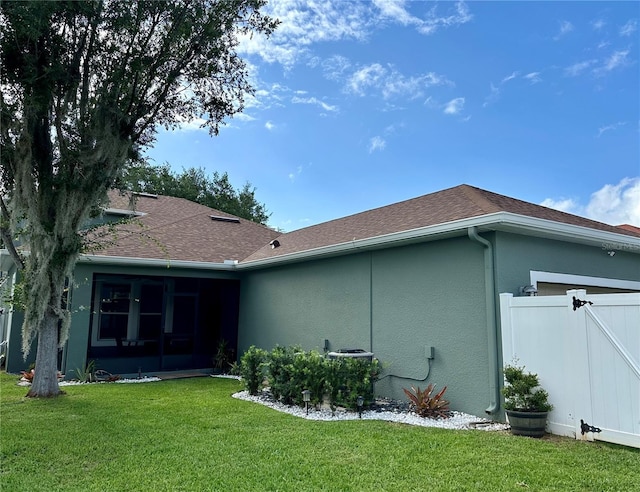 3339 Primrose Willow Dr, Saint Cloud, FL 34773 - rear view of house with stucco siding, a sunroom, roof with shingles, and a garage