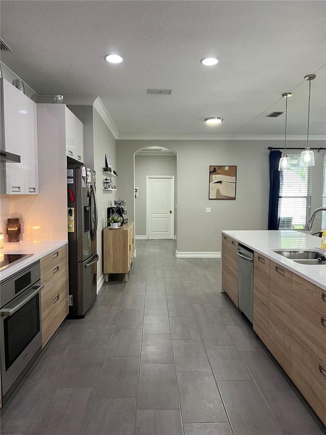 3339 Primrose Willow Dr, Saint Cloud, FL 34773 - kitchen with appliances with stainless steel finishes, modern cabinets, crown molding, arched walkways, and light countertops