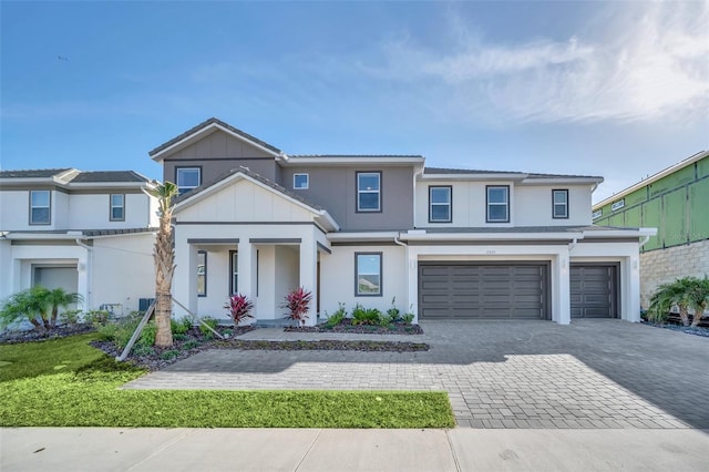 2525 Shanti Dr, Kissimmee, FL 34746 - view of front of property with decorative driveway, a garage, stucco siding, covered porch, and board and batten siding