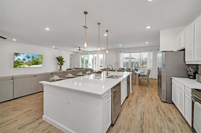 2525 Shanti Dr, Kissimmee, FL 34746 - kitchen with ceiling fan, light wood-style floors, open floor plan, white cabinets, and dishwasher