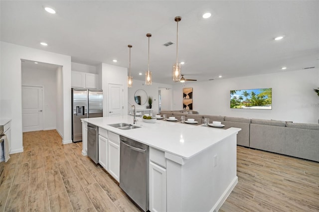 2525 Shanti Dr, Kissimmee, FL 34746 - kitchen featuring stainless steel appliances, open floor plan, light wood-style floors, recessed lighting, and a kitchen island with sink