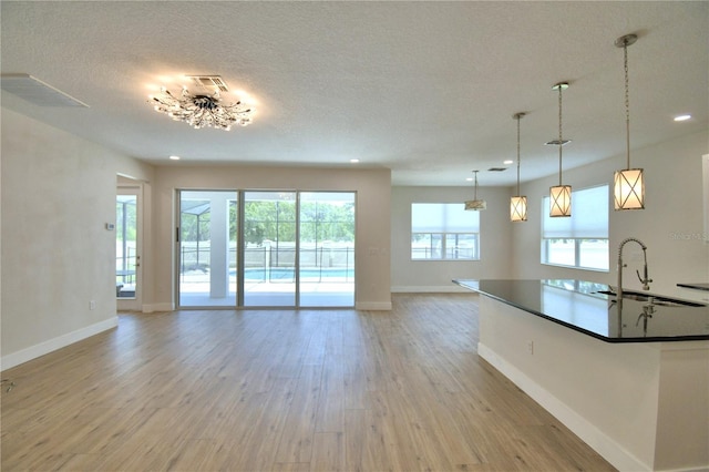 2673 Calistoga Ave, Kissimmee, FL 34741 - unfurnished living room featuring light wood finished floors, recessed lighting, and a textured ceiling