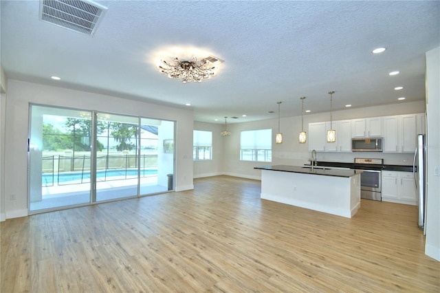 2673 Calistoga Ave, Kissimmee, FL 34741 - kitchen with appliances with stainless steel finishes, open floor plan, recessed lighting, dark countertops, and light wood finished floors