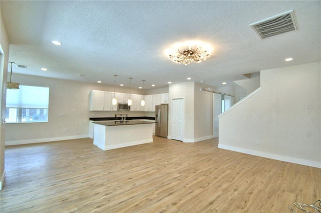 2673 Calistoga Ave, Kissimmee, FL 34741 - kitchen featuring open floor plan, stainless steel appliances, dark countertops, recessed lighting, and light wood-style flooring