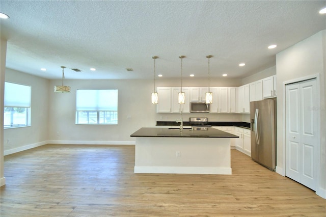 2673 Calistoga Ave, Kissimmee, FL 34741 - kitchen featuring appliances with stainless steel finishes, dark countertops, a textured ceiling, white cabinetry, and recessed lighting