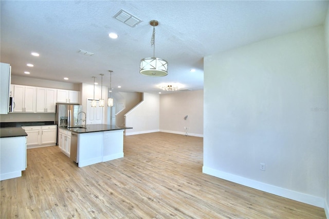 2673 Calistoga Ave, Kissimmee, FL 34741 - kitchen featuring dark countertops, recessed lighting, white cabinetry, light wood-style flooring, and decorative light fixtures