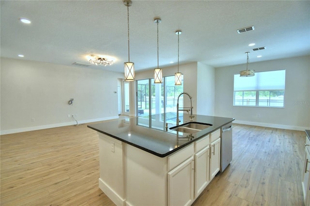 2673 Calistoga Ave, Kissimmee, FL 34741 - kitchen with open floor plan, dark countertops, stainless steel dishwasher, light wood-style floors, and recessed lighting