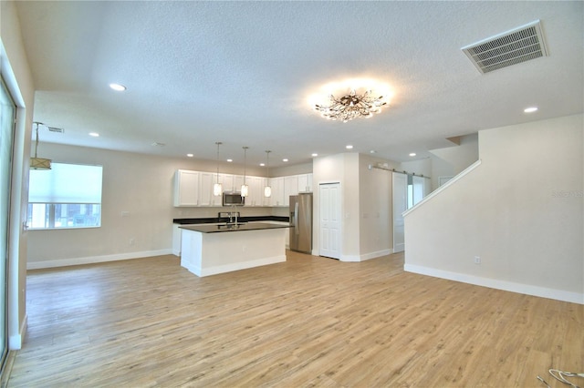 2673 Calistoga Ave, Kissimmee, FL 34741 - kitchen with open floor plan, stainless steel appliances, dark countertops, white cabinets, and recessed lighting