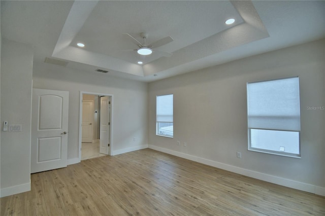 2673 Calistoga Ave, Kissimmee, FL 34741 - empty room featuring a tray ceiling, ceiling fan, light wood-style flooring, and recessed lighting