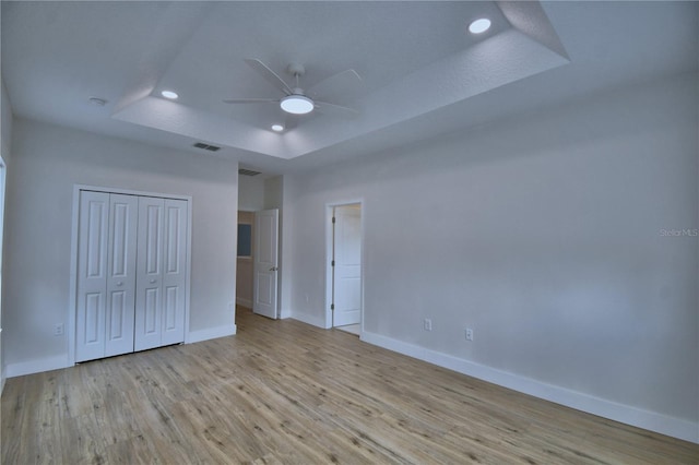 2673 Calistoga Ave, Kissimmee, FL 34741 - unfurnished bedroom with a tray ceiling, recessed lighting, wood finished floors, a closet, and ceiling fan