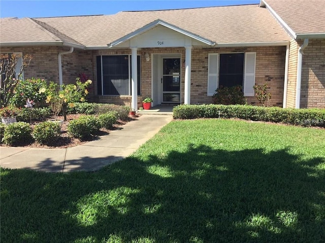 904 Michigan Ave, Saint Cloud, FL 34769 - ranch-style home featuring brick siding, a front lawn, and a shingled roof