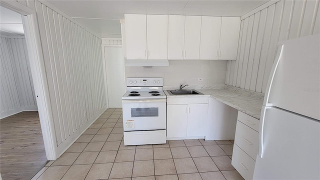 10301 US Highway 27 Unit 94B, Clermont, FL 34711 - kitchen with white appliances, under cabinet range hood, light tile patterned floors, and white cabinetry
