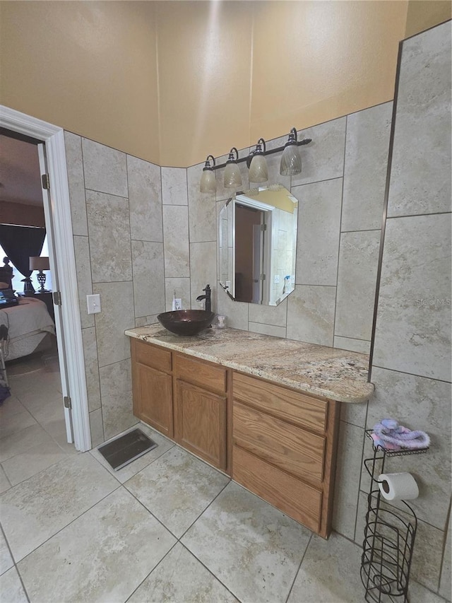 204 Canary Island Cir, Davenport, FL 33837 - bathroom featuring tile walls, connected bathroom, vanity, and tile patterned flooring