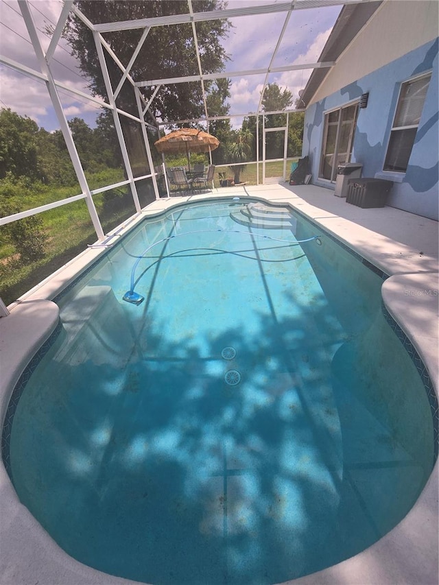 204 Canary Island Cir, Davenport, FL 33837 - pool at dusk featuring an outdoor pool, a patio, and glass enclosure