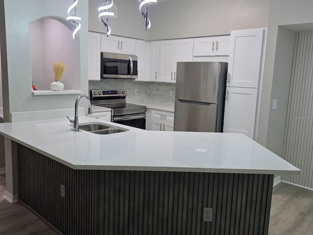3428 Soho St Unit 208, Orlando, FL 32835 - kitchen featuring appliances with stainless steel finishes, wood finished floors, white cabinetry, and tasteful backsplash