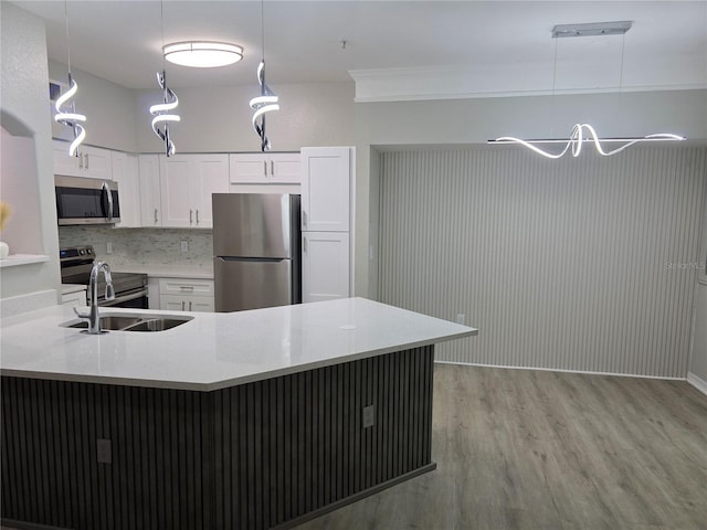 3428 Soho St Unit 208, Orlando, FL 32835 - kitchen with appliances with stainless steel finishes, light wood-style flooring, white cabinetry, light countertops, and pendant lighting