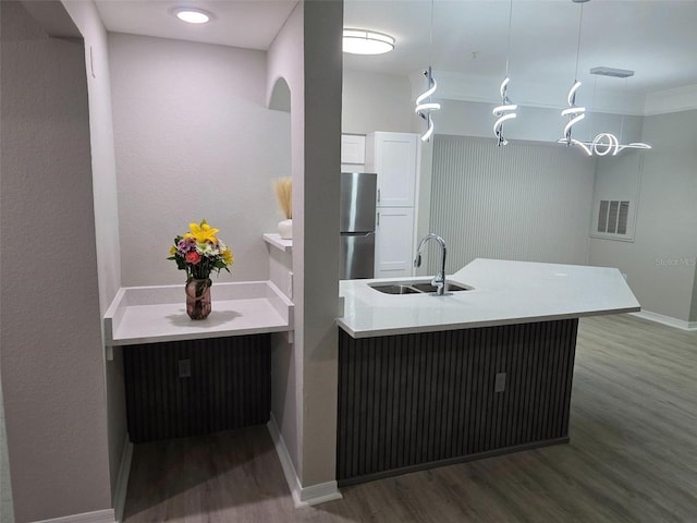 3428 Soho St Unit 208, Orlando, FL 32835 - kitchen featuring wood finished floors, freestanding refrigerator, white cabinets, and pendant lighting
