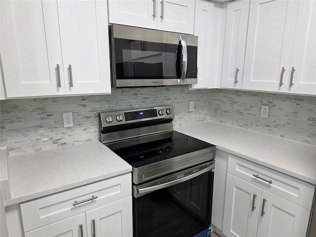 3428 Soho St Unit 208, Orlando, FL 32835 - kitchen featuring stainless steel appliances, backsplash, and white cabinets