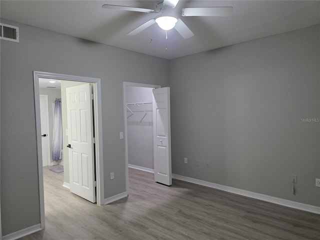 3428 Soho St Unit 208, Orlando, FL 32835 - unfurnished bedroom featuring wood finished floors, a spacious closet, a closet, and a ceiling fan