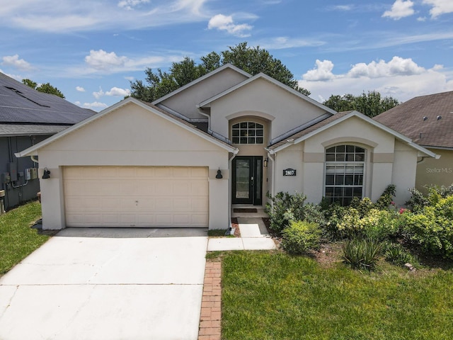 2807 Playing Otter Ct, Kissimmee, FL 34747 - view of front facade featuring stucco siding, an attached garage, concrete driveway, and a front lawn