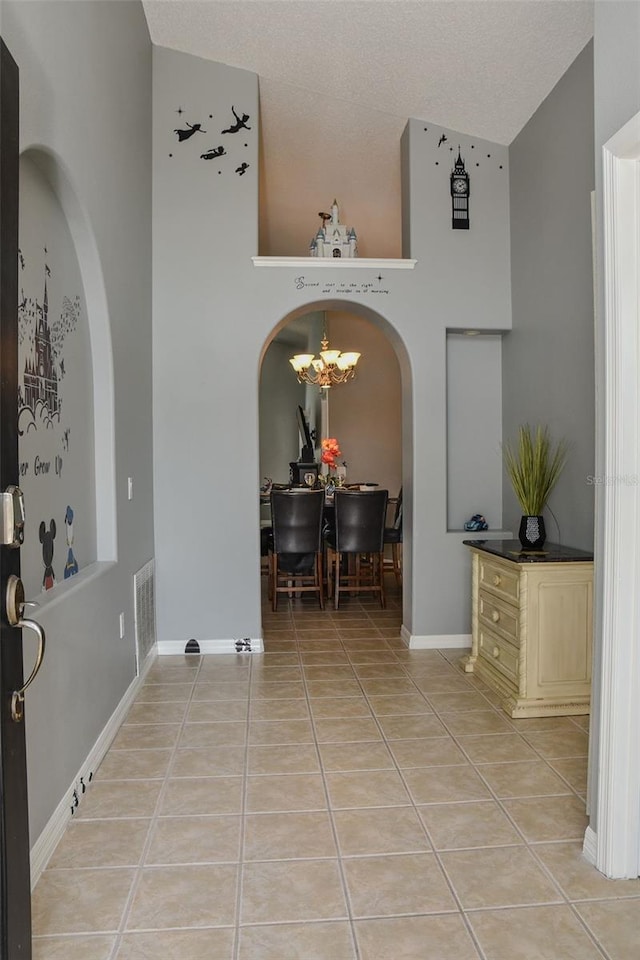 2807 Playing Otter Ct, Kissimmee, FL 34747 - entrance foyer with arched walkways, light tile patterned flooring, a chandelier, and high vaulted ceiling