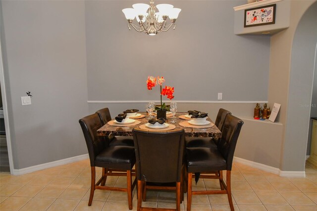 2807 Playing Otter Ct, Kissimmee, FL 34747 - dining room with a chandelier, arched walkways, and light tile patterned floors