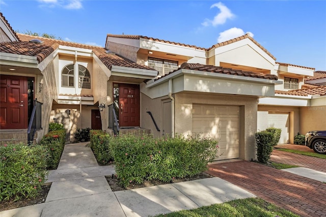 17340 Boca Club Blvd Unit 703, Boca Raton, FL 33487 - view of property featuring stucco siding, a tiled roof, and decorative driveway